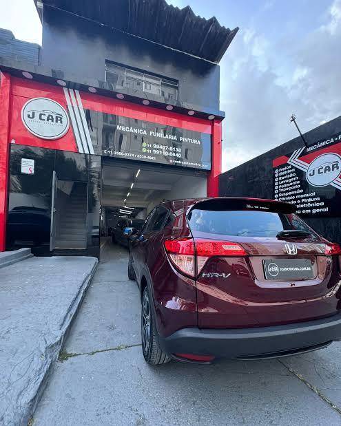 Fachada da Jcar vista da rua, com um carro vermelho parado na frente.